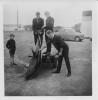 The men lift the Dolphin onto the trolley cart.