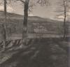 A rural scene, with a large house surrounded by trees and mountains in the background