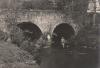 Fishing in a small river beneath an old bridge