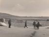 People walking on a rough road beside stone walls