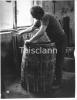 A cooper assembling a whiskey barrel at Powers works in Dublin.