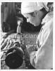 Young woman turning a piece of wood on a lathe.