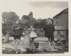 Three young children at the water pump. 